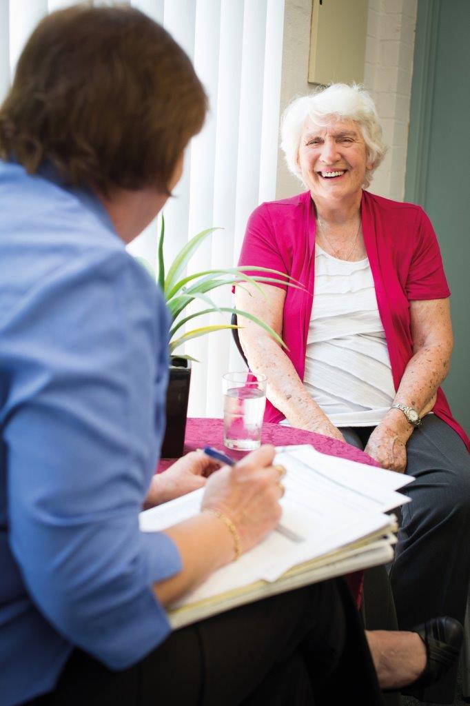 Older woman with therapist holding a pen and paper